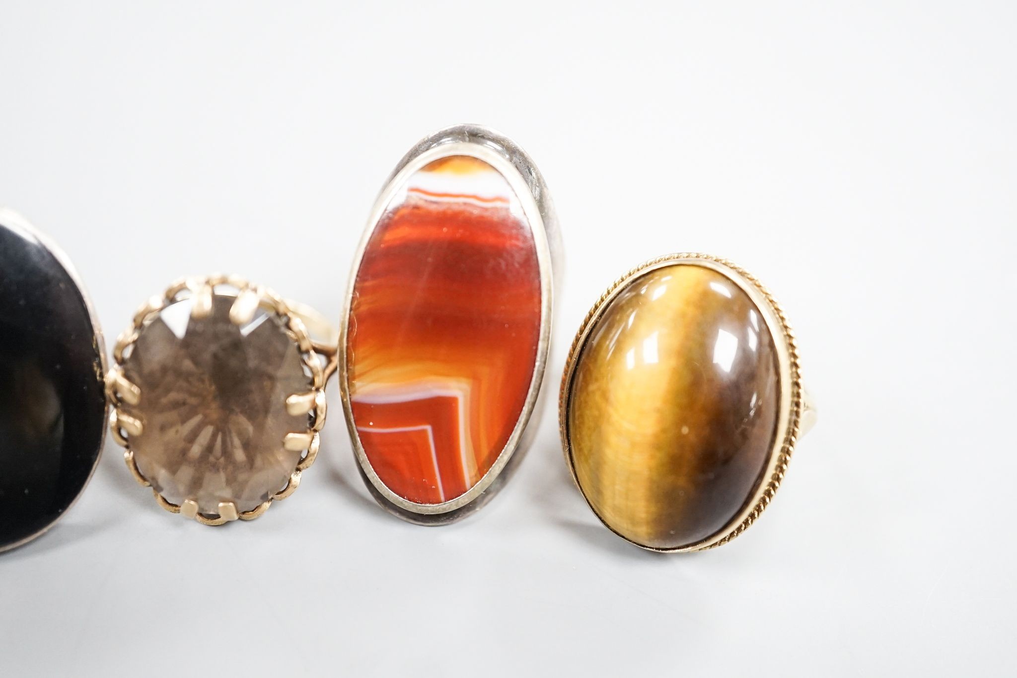 Three assorted 9ct gold and gem set dress rings, including blue john, smoky quartz and tiger's eye quartz, gross 23.9 grams and two white metal and hardstone set dress rings.